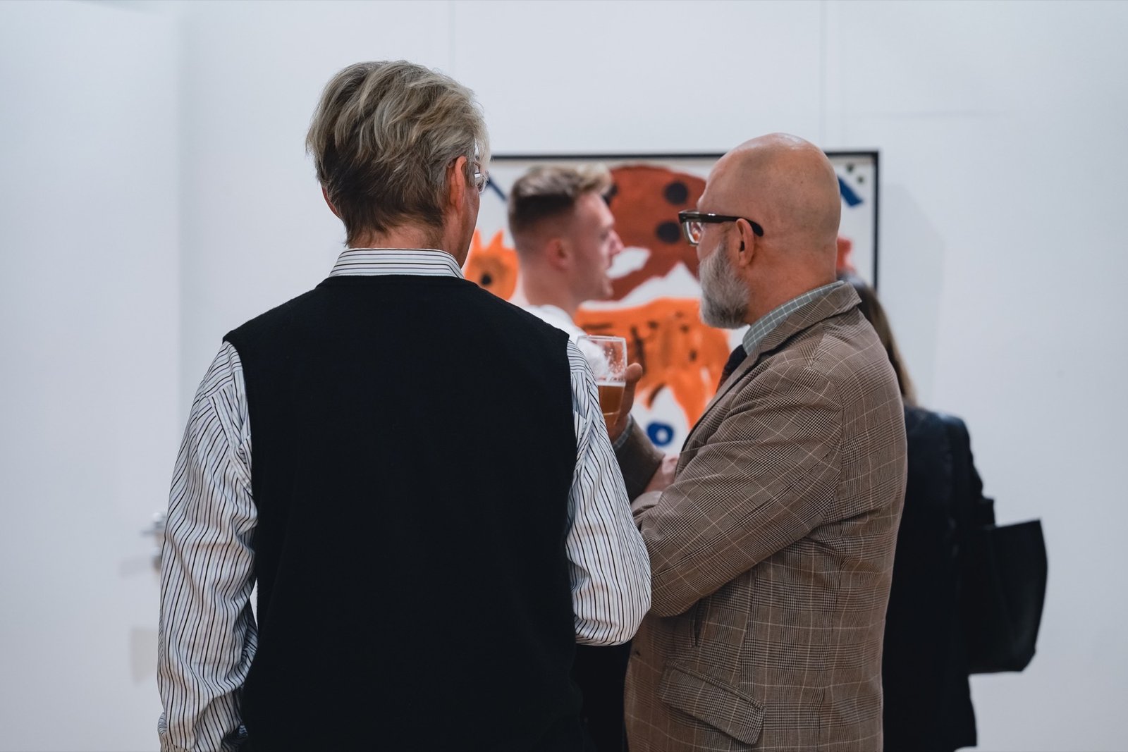 Gäste im Gespräch bei einer Kunstausstellung